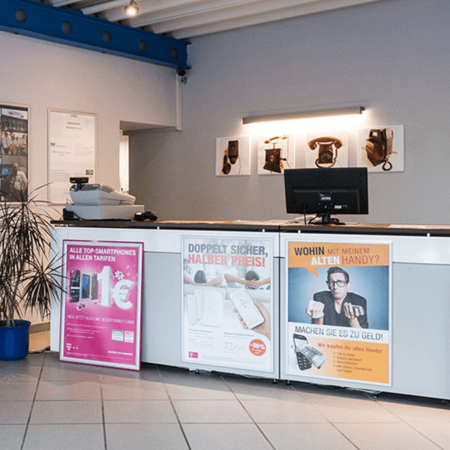 Moderner Handyshop mit Tresen, Werbepostern zu Smartphones und Handyankauf im Eingangsbereich.