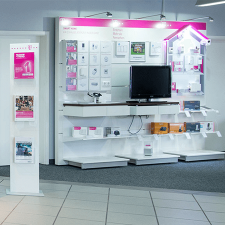 Smart-Home-Ausstellung im Telekom-Shop mit modernen Geräten, Fernseher und Prospekten.
